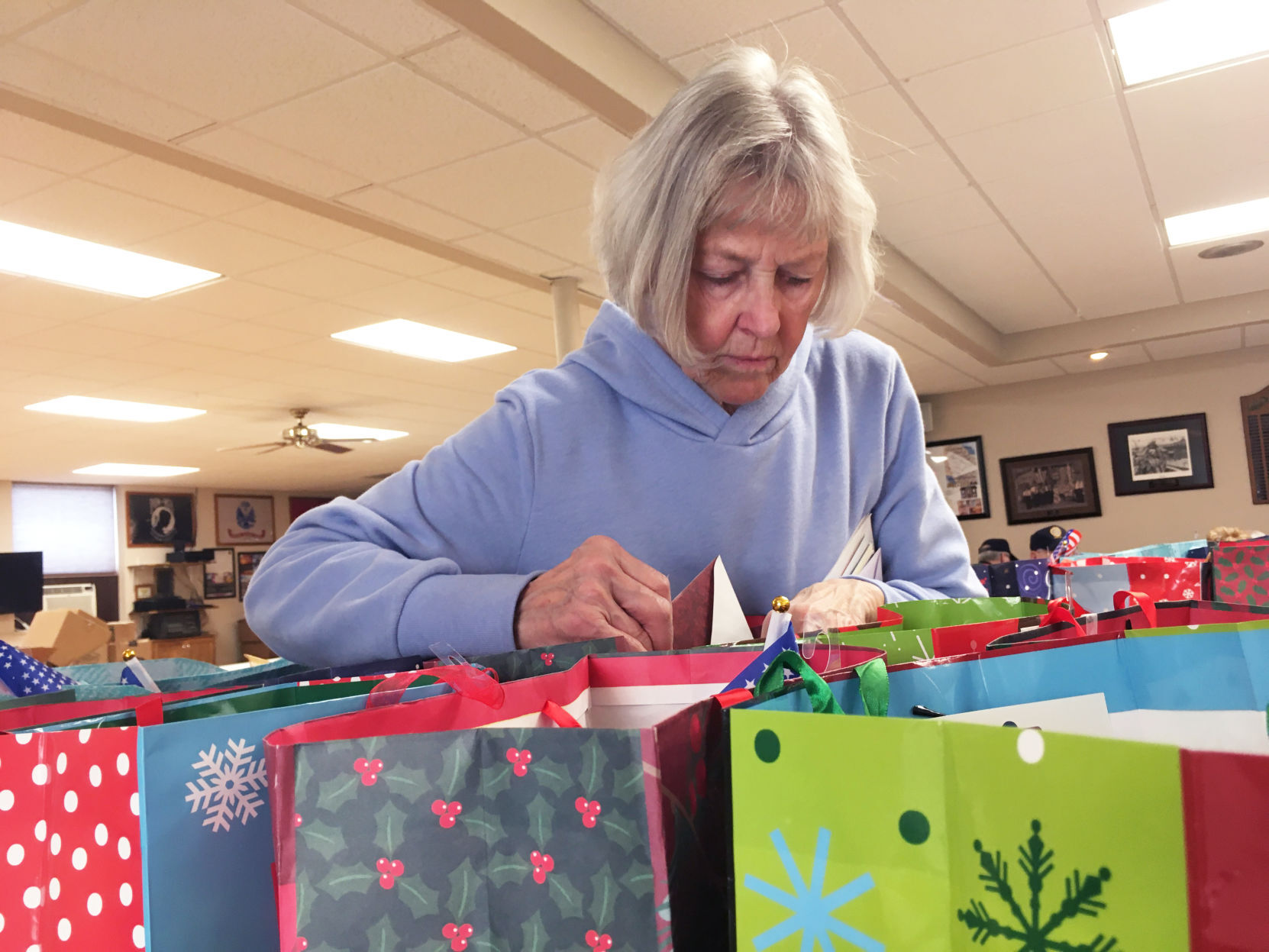 Carol Amborn adds cards to gift bags for delivery to veterans homes